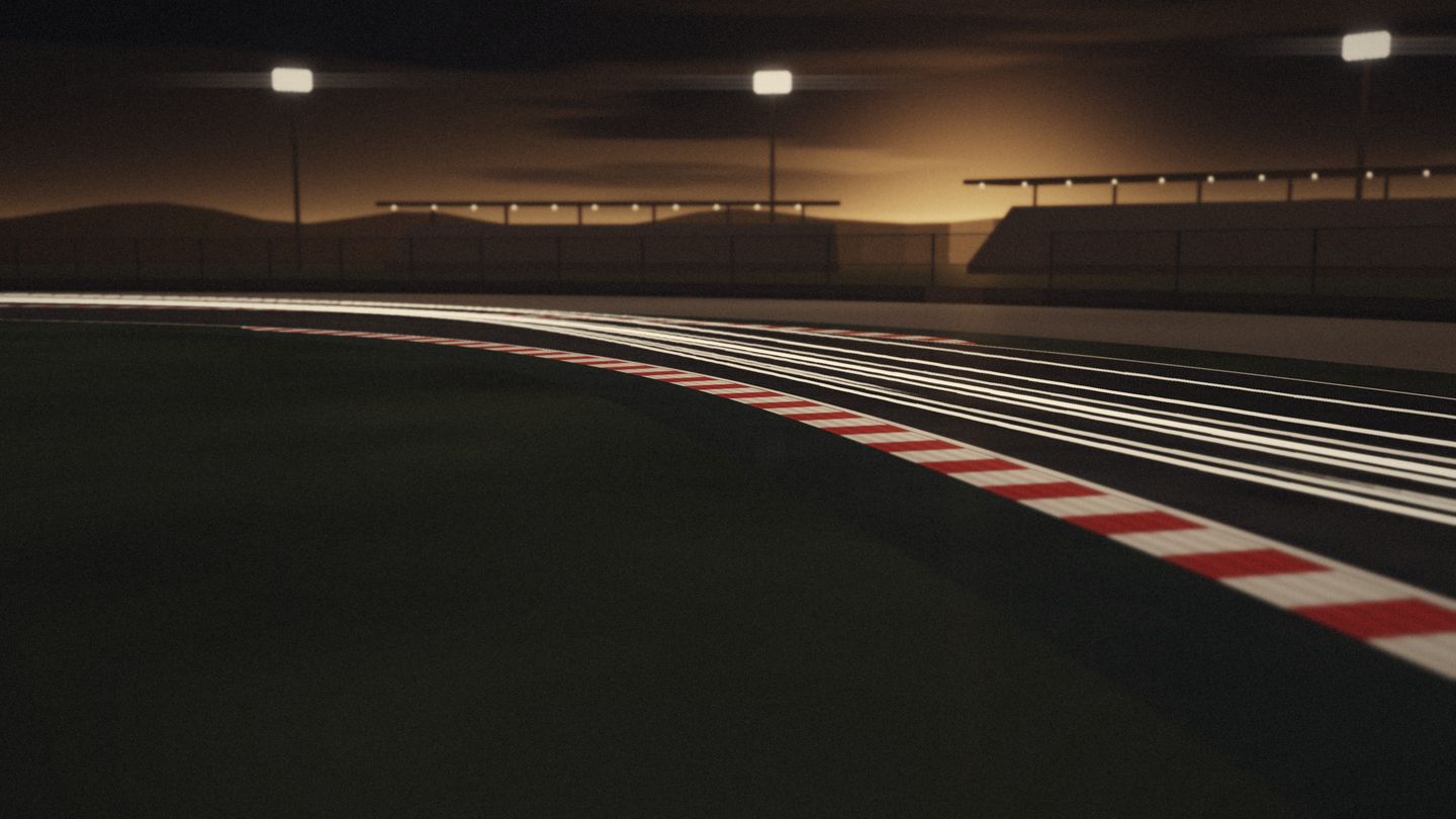 A floodlit circuit as night falls: light trails sweep through a corner past a red and white apex kerb, with grandstands silhouetted against the last light.